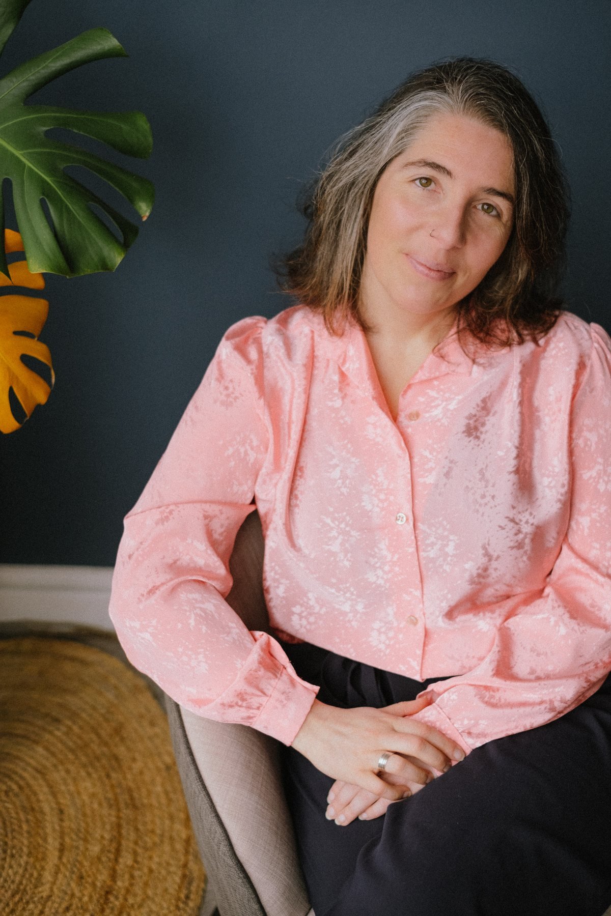 Portrait de Mélody Blocquel, assise, en chemisier rose
