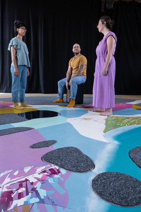Deux interprètes et un musicien sur la scénographie-puzzle colorée de Peuplé·e·s