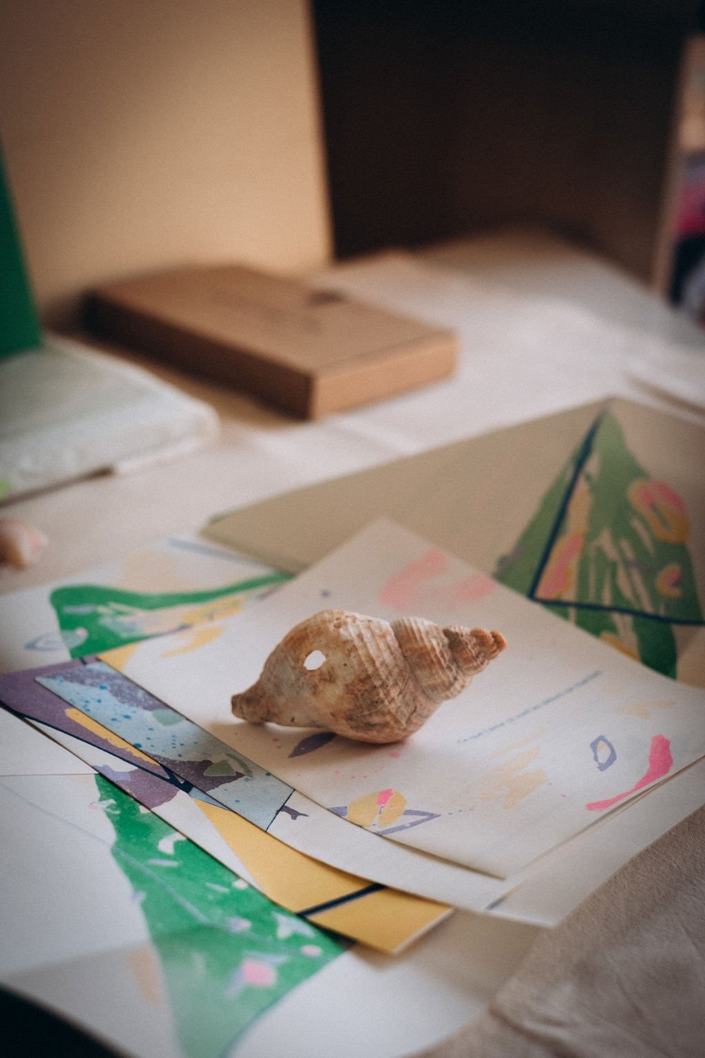 Pages illustrées de Peuplé·e·s dépliées sur une table, avec un coquillage