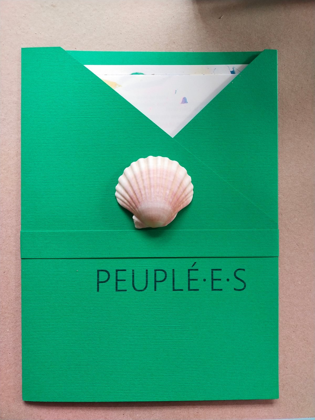 Couverture verte du livre Peuplé·e·s, un coquillage posé dessus