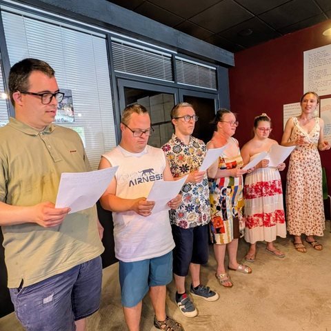 Un groupe lit ses textes à voix haute, feuilles en main